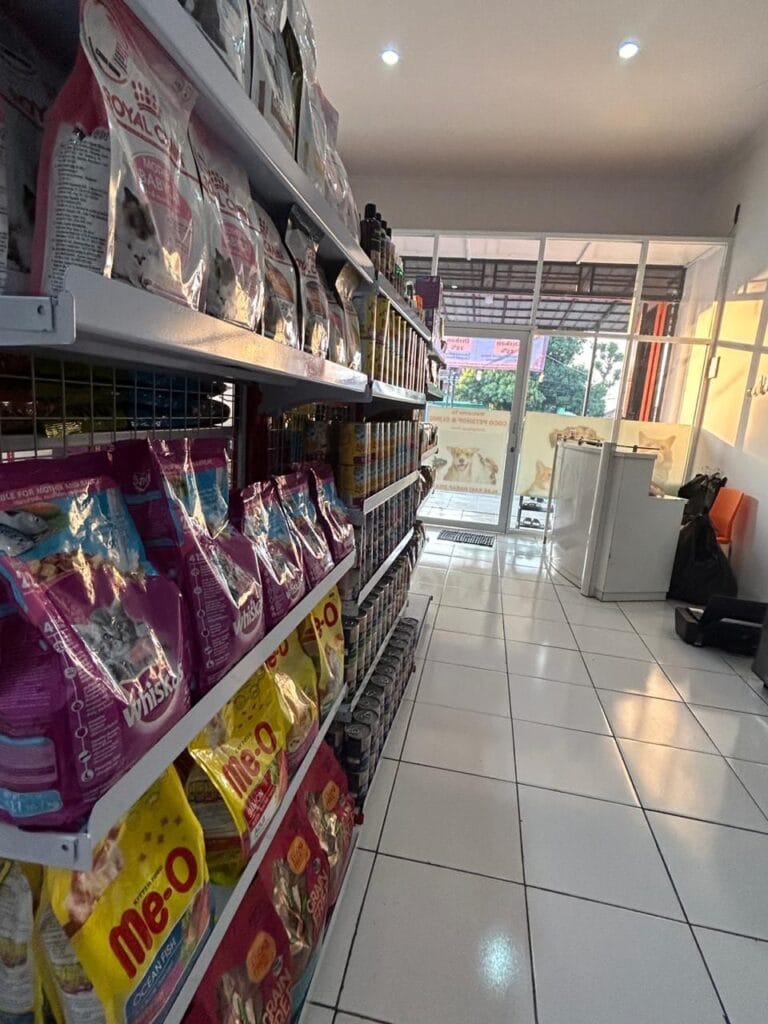 Rak makanan kucing di klinik hewan Depok, termasuk merek Royal Canin dan Whiskas.